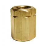 A brass nut is sitting on the ground.